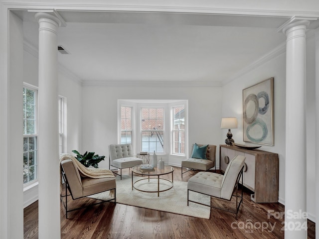 living area with ornate columns, plenty of natural light, ornamental molding, and dark hardwood / wood-style floors