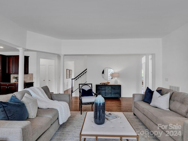 living room featuring decorative columns and light hardwood / wood-style flooring