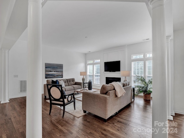 living room with dark wood-type flooring and ornate columns