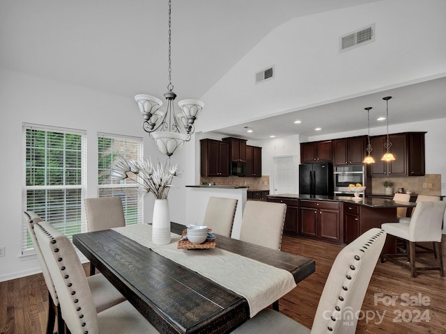 dining space with dark wood-type flooring, an inviting chandelier, and high vaulted ceiling