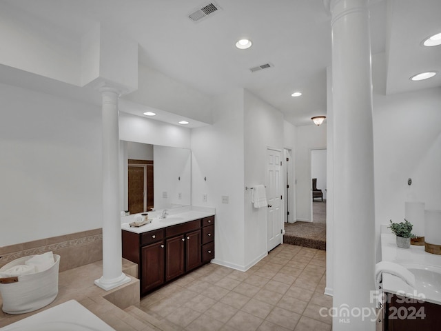 bathroom featuring vanity, ornate columns, and a bathtub