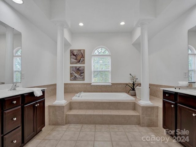 bathroom featuring vanity, decorative columns, tile patterned floors, and tiled tub