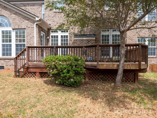 rear view of house with a deck and a lawn