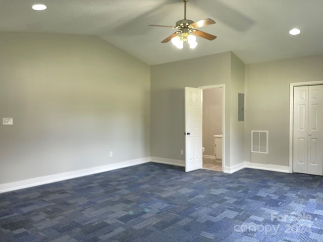 unfurnished bedroom featuring electric panel, ceiling fan, dark carpet, and vaulted ceiling