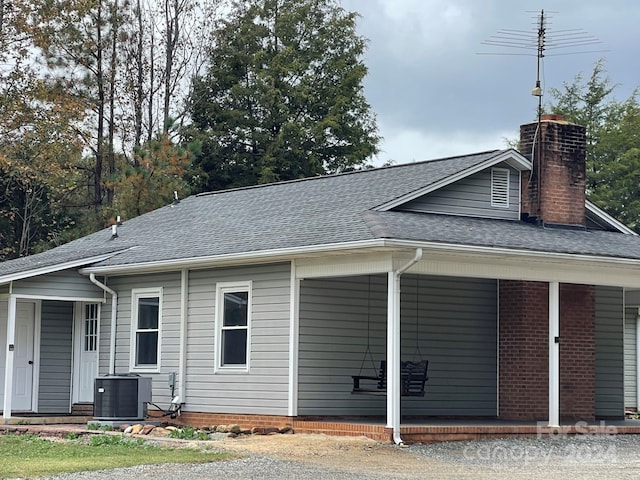 back of property featuring central AC and covered porch