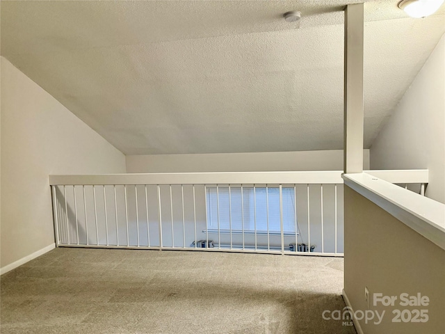 interior space with lofted ceiling, carpet, and a textured ceiling