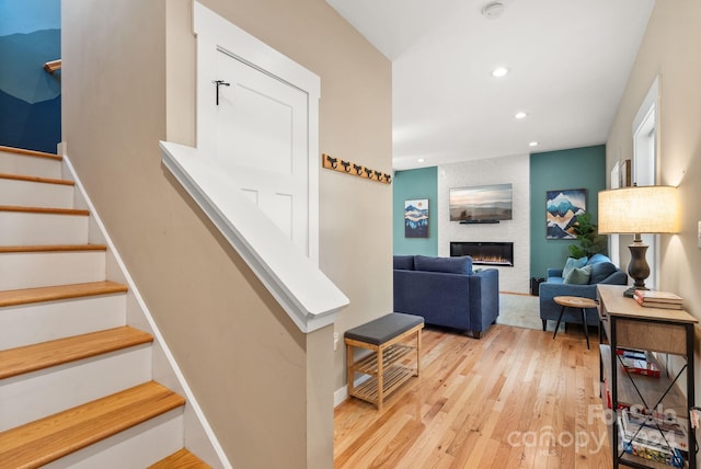 stairway with a fireplace and wood-type flooring