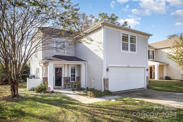 view of property with a garage and a front lawn