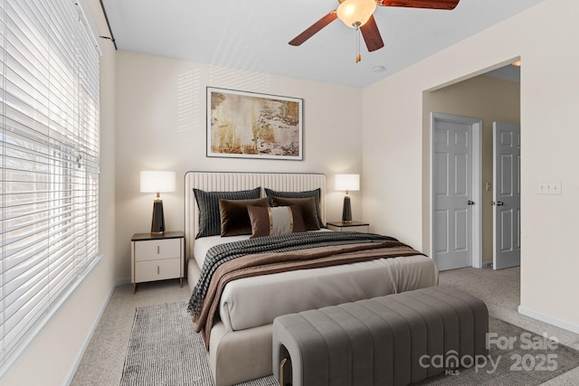 bedroom with ceiling fan, multiple windows, and light carpet