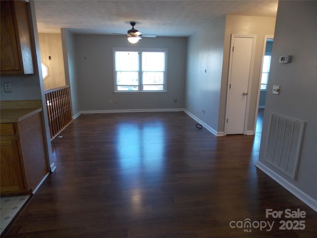 unfurnished dining area with ceiling fan and dark wood-type flooring