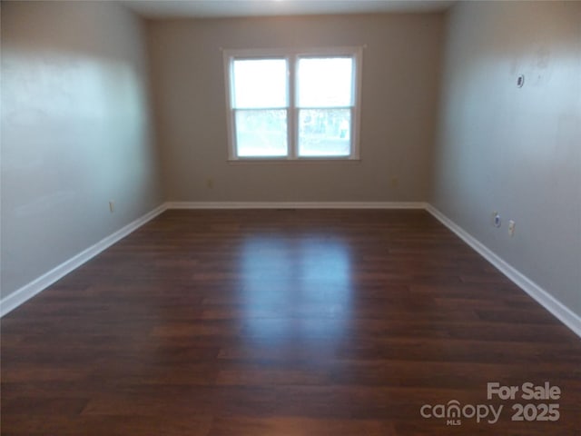 unfurnished room with dark hardwood / wood-style flooring