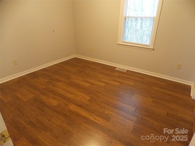 unfurnished room featuring dark wood-type flooring