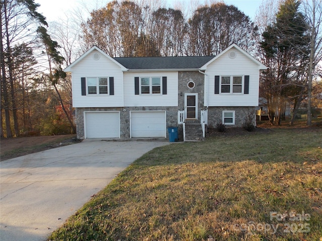 raised ranch featuring a garage and a front lawn