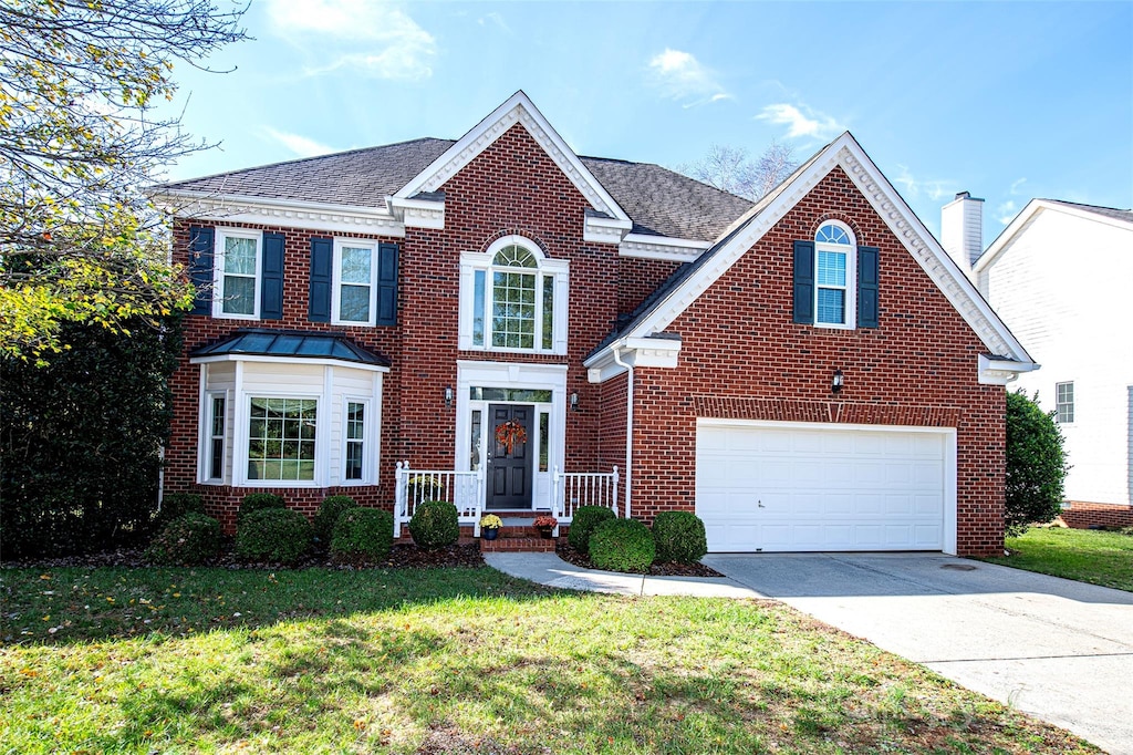 view of front of property with a front yard and a garage