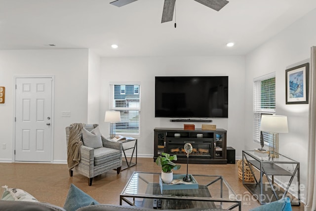 living room featuring ceiling fan, plenty of natural light, and light hardwood / wood-style floors