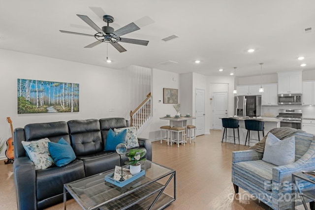 living room featuring ceiling fan and light wood-type flooring