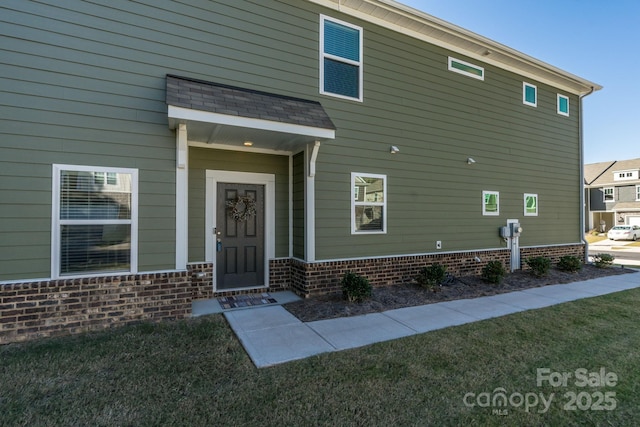 view of exterior entry with a lawn