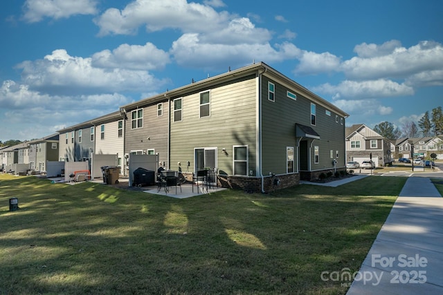 rear view of property with a yard and a patio