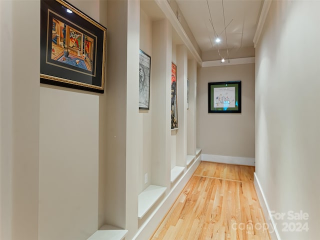 hall with hardwood / wood-style flooring and crown molding