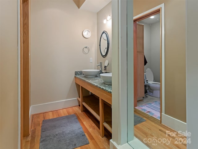 bathroom with toilet, vanity, and hardwood / wood-style flooring