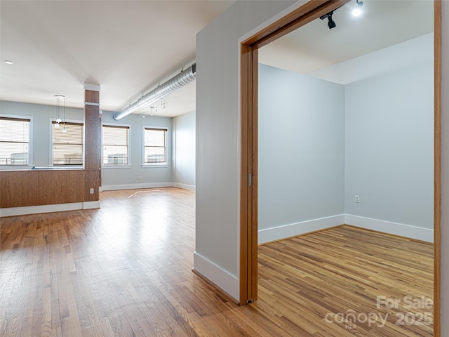 32 Broadway St Unit 230, Asheville, NC 28801 - unfurnished room with baseboards, track lighting, and hardwood / wood-style flooring