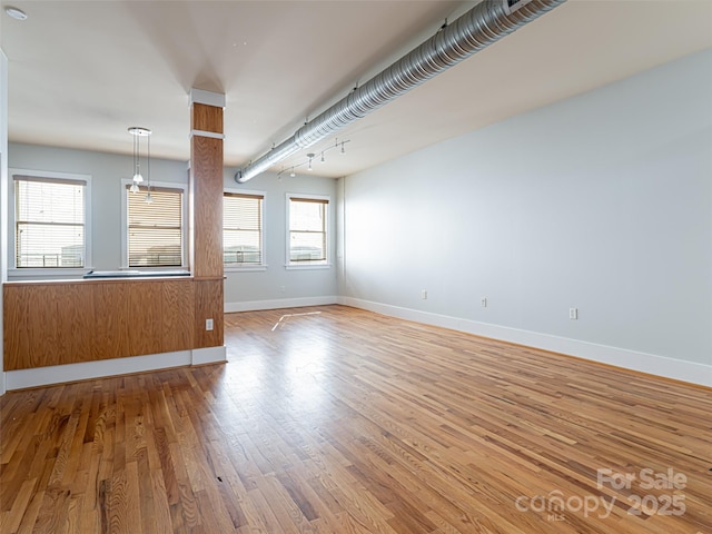 32 Broadway St Unit 230, Asheville, NC 28801 - unfurnished living room featuring baseboards and wood finished floors