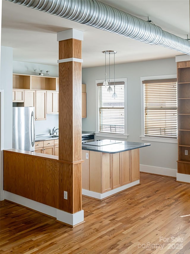 32 Broadway St Unit 230, Asheville, NC 28801 - kitchen with light wood finished floors, freestanding refrigerator, a sink, cooktop, and decorative light fixtures