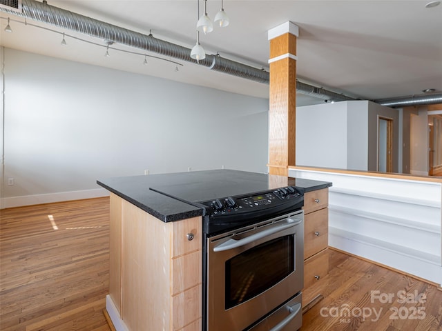 32 Broadway St Unit 230, Asheville, NC 28801 - kitchen with light brown cabinets, baseboards, light wood-style flooring, stainless steel range with electric stovetop, and dark countertops