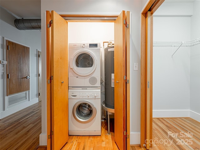 32 Broadway St Unit 230, Asheville, NC 28801 - laundry area with visible vents, electric water heater, wood finished floors, stacked washer / dryer, and laundry area