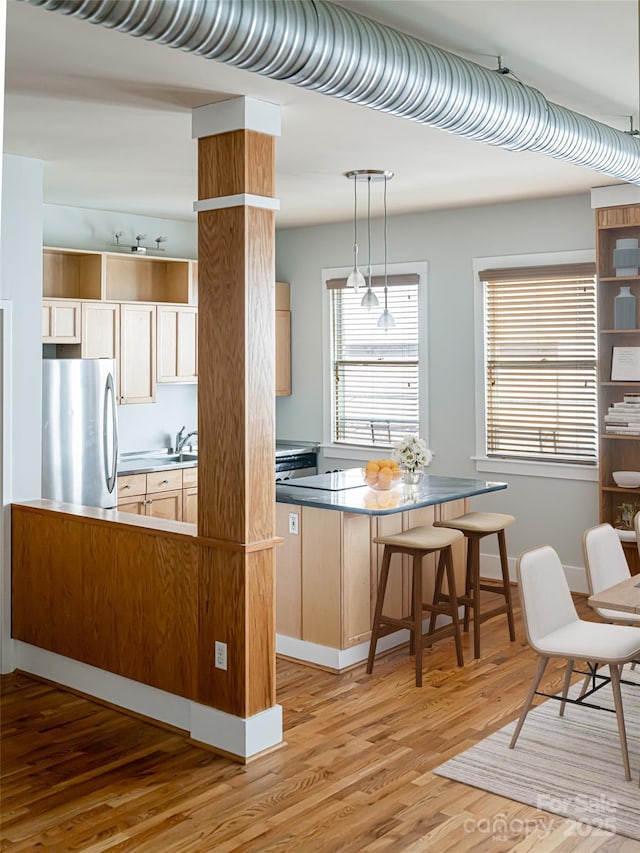32 Broadway St Unit 230, Asheville, NC 28801 - kitchen with light wood finished floors, a healthy amount of sunlight, a breakfast bar, and freestanding refrigerator