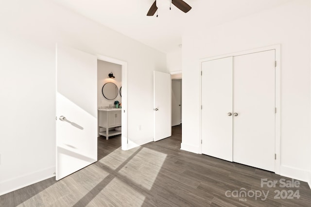 unfurnished bedroom with a closet, ensuite bath, ceiling fan, and dark hardwood / wood-style floors