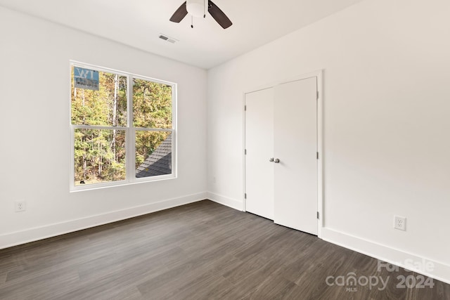 unfurnished bedroom with dark hardwood / wood-style flooring, ceiling fan, and a closet