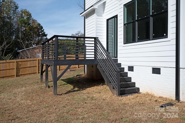 view of property exterior featuring a lawn and a wooden deck