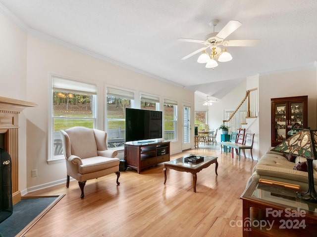 living room featuring light wood-type flooring, ceiling fan, and crown molding