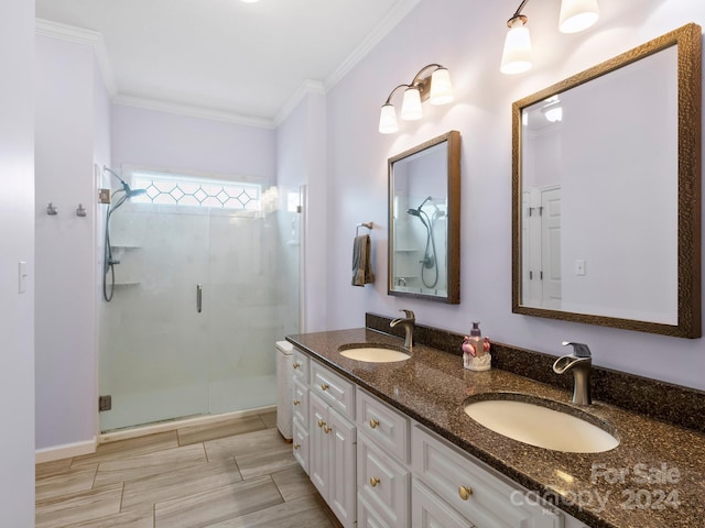 bathroom featuring a shower with door, vanity, and ornamental molding