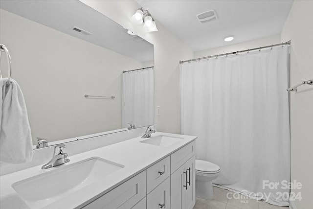 bathroom with vanity, tile patterned flooring, and toilet