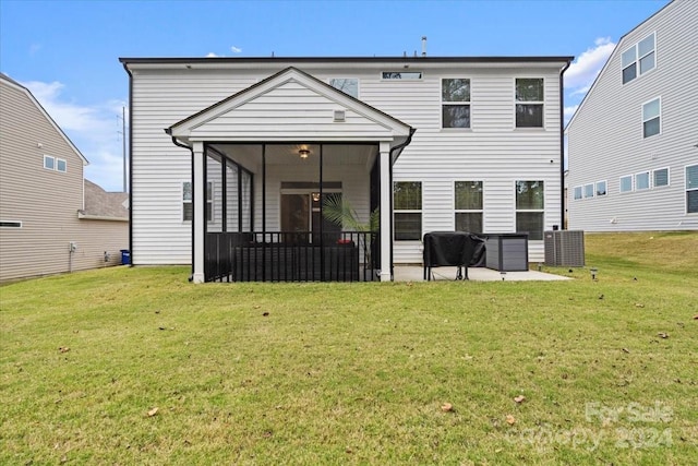 back of house featuring a sunroom, a patio, and a yard