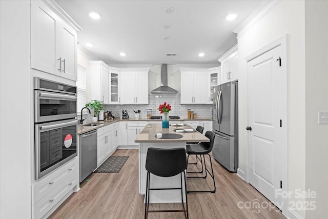 122 W Heart Pine Ln, Statesville, NC 28677 - kitchen with wall chimney exhaust hood, appliances with stainless steel finishes, a sink, a breakfast bar area, and white cabinetry