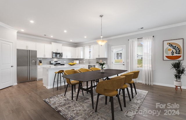 dining area with ornamental molding and dark hardwood / wood-style floors