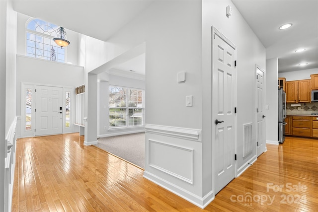 entryway featuring light wood-type flooring and ornamental molding