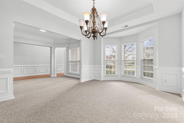 carpeted spare room featuring a chandelier, a raised ceiling, and crown molding