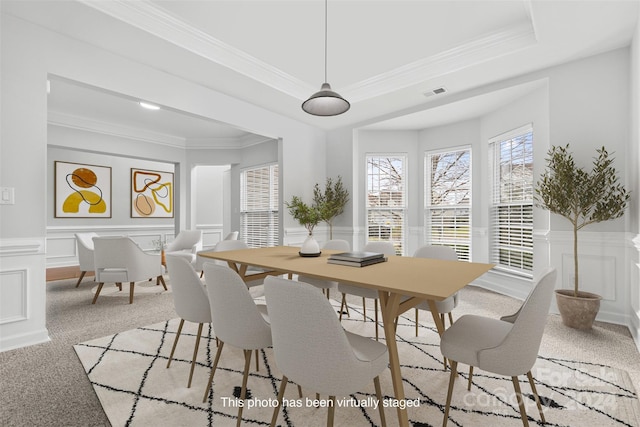 dining space with light colored carpet, crown molding, and a tray ceiling