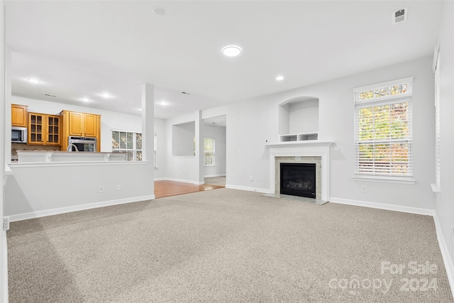 unfurnished living room featuring light colored carpet