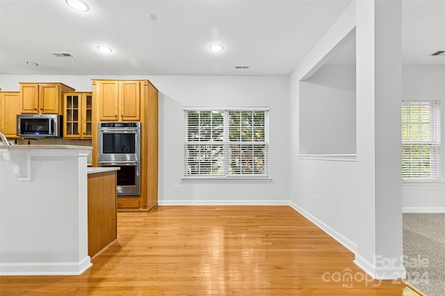 kitchen featuring a breakfast bar area, light hardwood / wood-style flooring, and appliances with stainless steel finishes