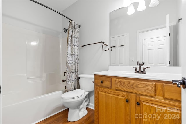 full bathroom featuring wood-type flooring, vanity, shower / tub combo, and toilet