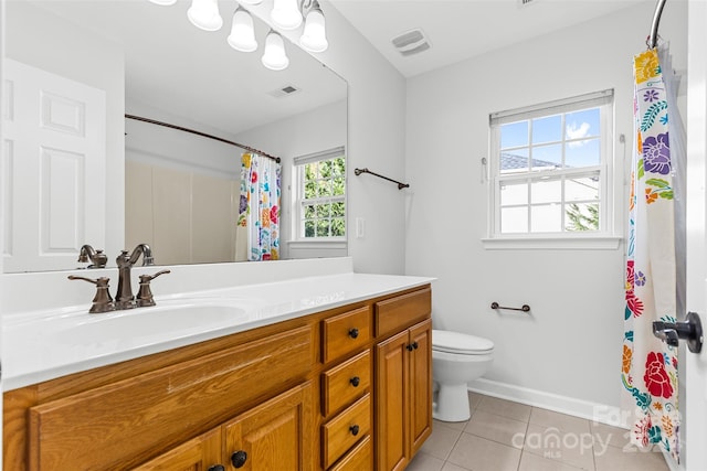 bathroom featuring tile patterned flooring, vanity, toilet, and a wealth of natural light