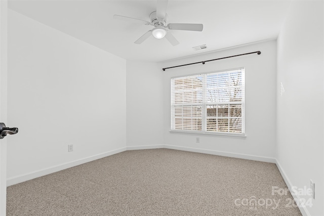 carpeted spare room featuring ceiling fan