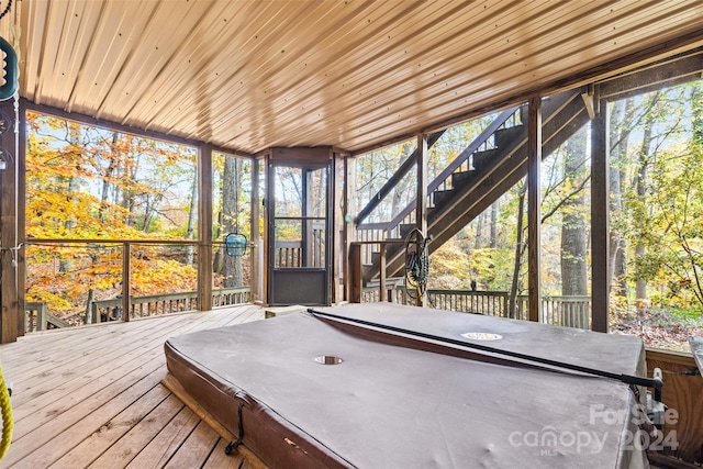 unfurnished sunroom featuring wood ceiling and a hot tub