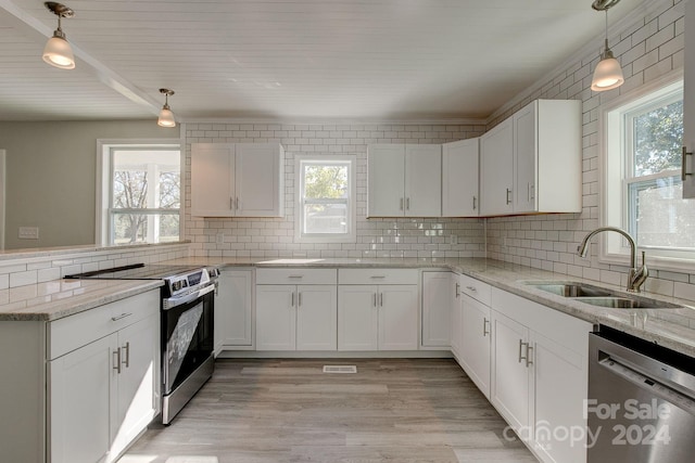 kitchen featuring pendant lighting, stainless steel appliances, and white cabinetry