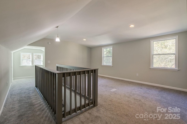 hall featuring baseboards, an upstairs landing, carpet, and lofted ceiling